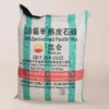 Bolsa de 50 kg de Parafina China con rayas blancas y verdes, etiquetada como "58 % de cera de parafina semirrefinada", de Daqing Petrochemical (KunLun), ideal para la fabricación de velas y de confianza para fabricantes colombianos. Se proporcionan datos del producto y de contacto.