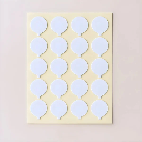 Stickers para Pabilos: hoja con 20 adhesivos circulares blancos sobre fondo beige claro, ideales para etiquetar insumos o empaques de fabricantes de velas en Colombia.